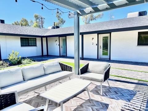 A modern outdoor patio area with a walkway and a covered seating area.