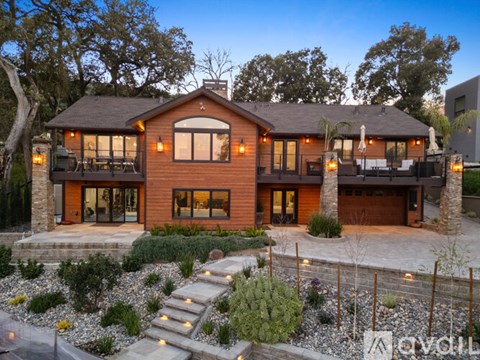 A modern house with a large front yard and landscaping.