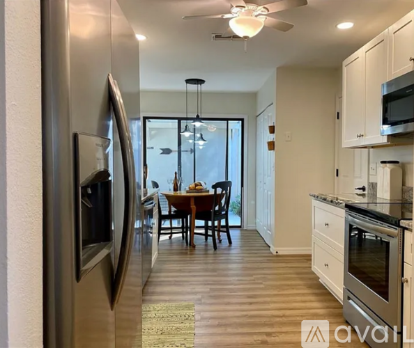 A modern kitchen with a dining table and chairs in the middle of the room.