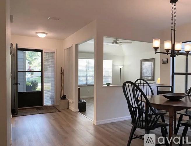 A dining room with a wooden table and chairs.