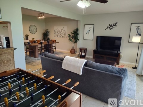 A living room with a foosball table in the foreground.