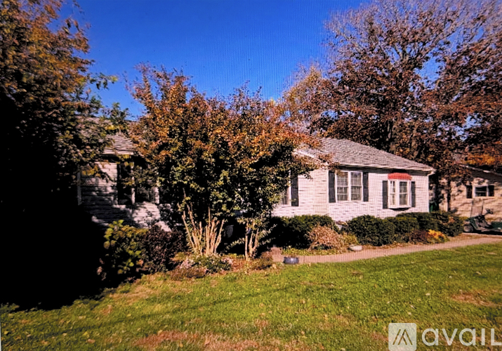 A house with a lawn and trees in front of it.
