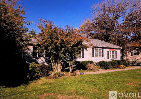 A house with a lawn and trees in front of it.