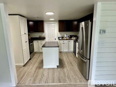 A kitchen with white cabinets and a white refrigerator.