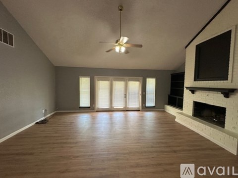 A spacious living room with a fireplace and a television.