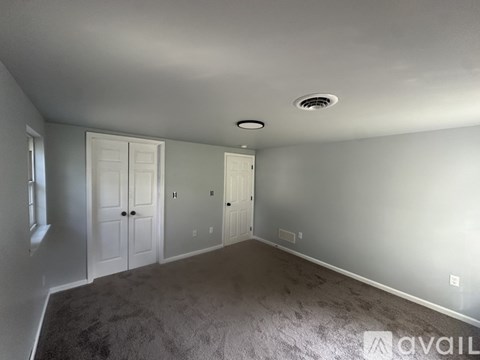 A room with grey carpet and white walls.