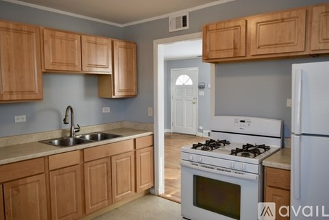 A kitchen with wooden cabinets and a white stove top oven.