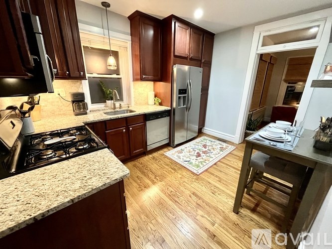 A kitchen with wooden cabinets and a granite countertop.