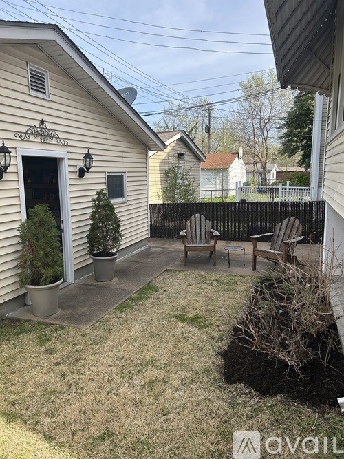 A small backyard with a patio and a small tree.