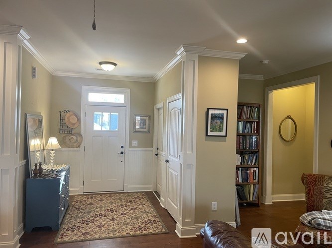 A living room with a rug, a couch, and a bookshelf.