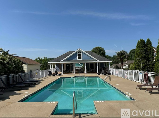 A pool with a house in the background.