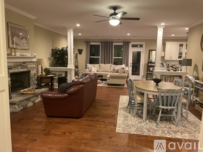 A living room with a fireplace and a dining table.
