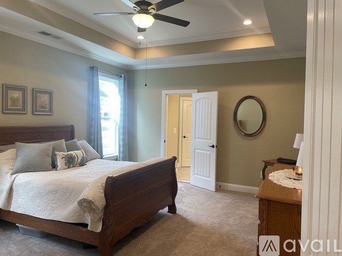 A bedroom with a large bed and a ceiling fan.