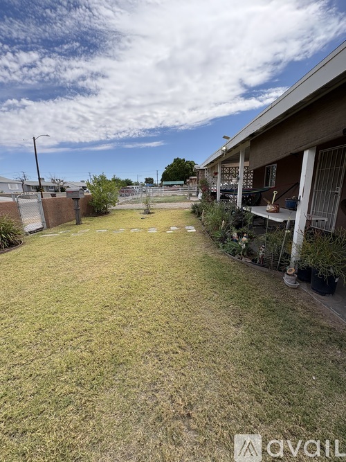 A backyard with a lawn and a house in the background.