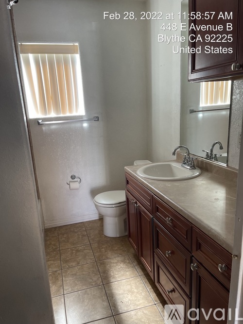 A bathroom with a toilet, sink, and mirror.