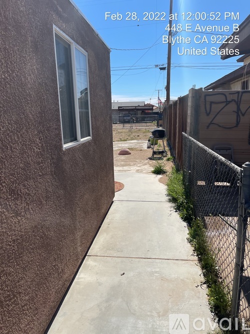 A brown building with a white window and a black fence in front of it.