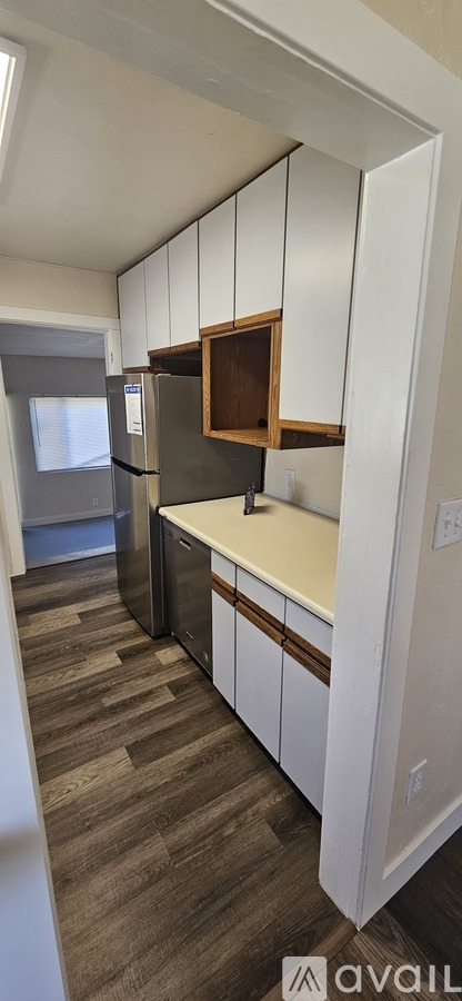 A kitchen with white cabinets and a refrigerator.