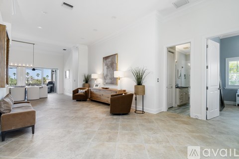 A spacious living room with a large couch and a painting on the wall.