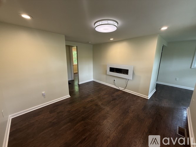 A room with a wooden floor and a white ceiling light.