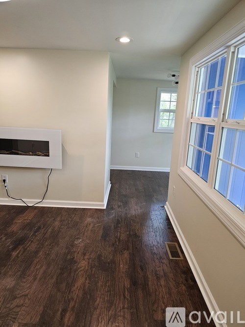 A room with a fireplace and wood flooring.