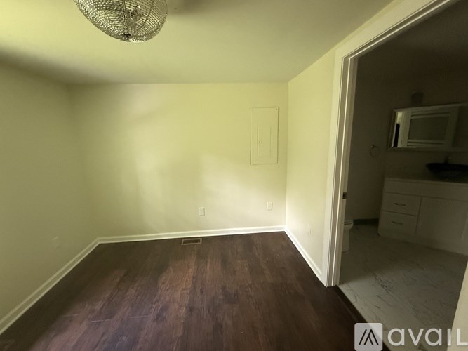 A room with wooden floors and a chandelier.