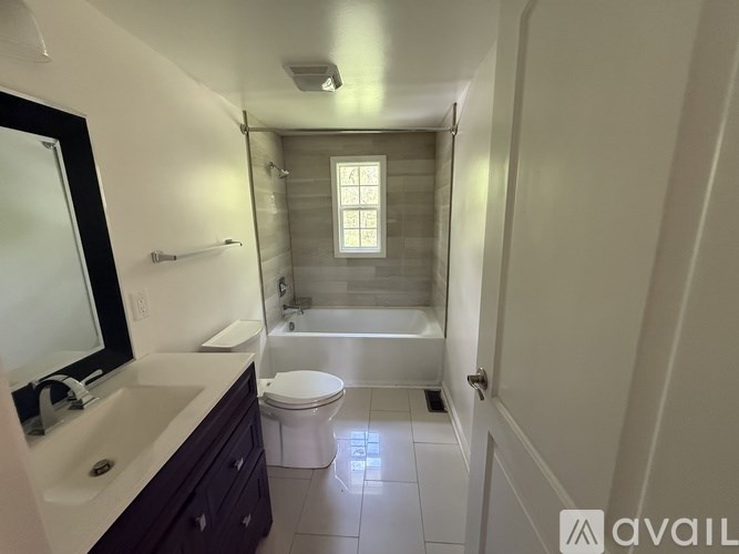 A bathroom with a toilet, sink, and bathtub.