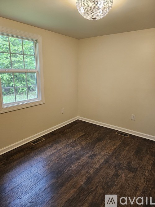 A room with wooden flooring and a window.