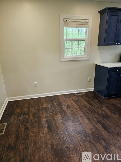 A room with a window and wooden flooring.