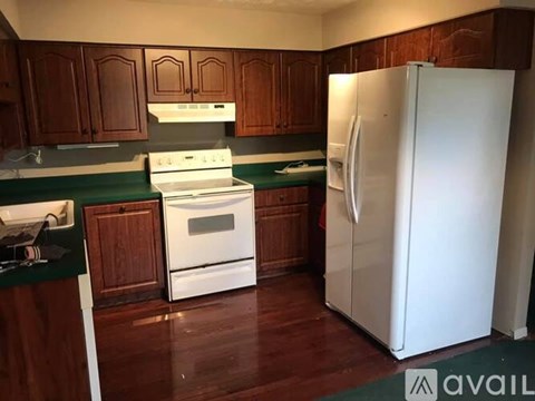 A kitchen with a white refrigerator, stove, and oven.