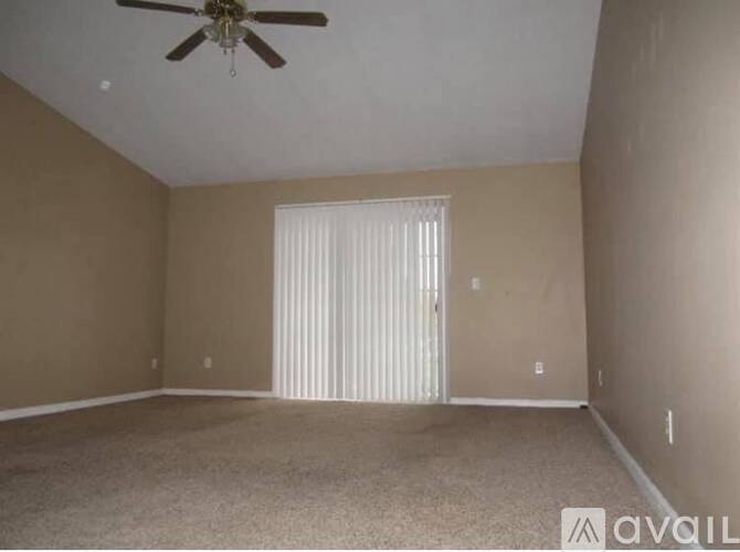 A room with a ceiling fan and carpeted floor.