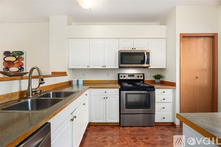 A kitchen with white cabinets and a black stove top oven.
