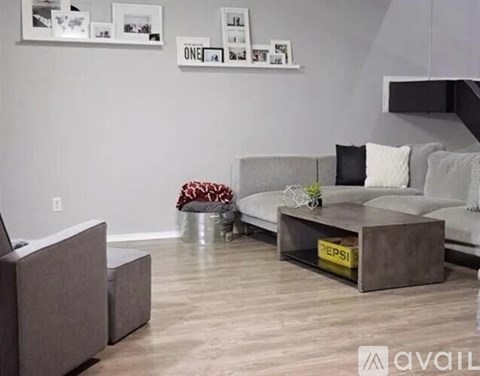 A living room with a grey couch and a coffee table with a Pepsi logo on it.