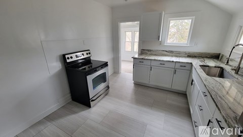 A kitchen with a black stove top oven and a marble counter top.