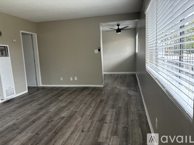A room with wooden flooring and a white door.
