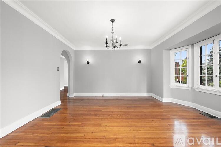 A room with wooden floors and a chandelier.