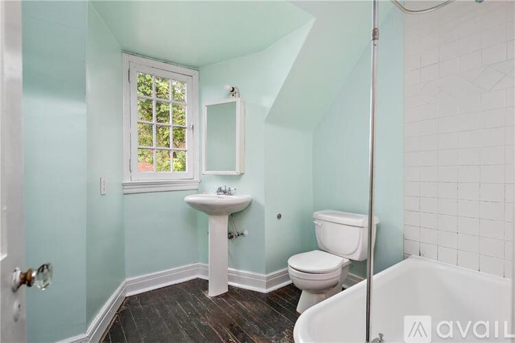 A bathroom with a white sink, toilet, and tub.