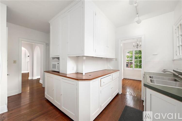 A kitchen with white cabinets and a wooden countertop.