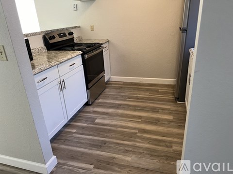 A kitchen with a black stove top oven and white cabinets.