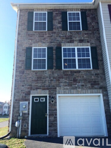 A brick house with a black door and a garage door.