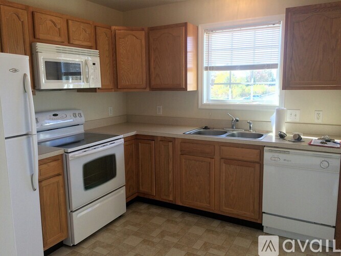 A kitchen with wooden cabinets and white appliances.