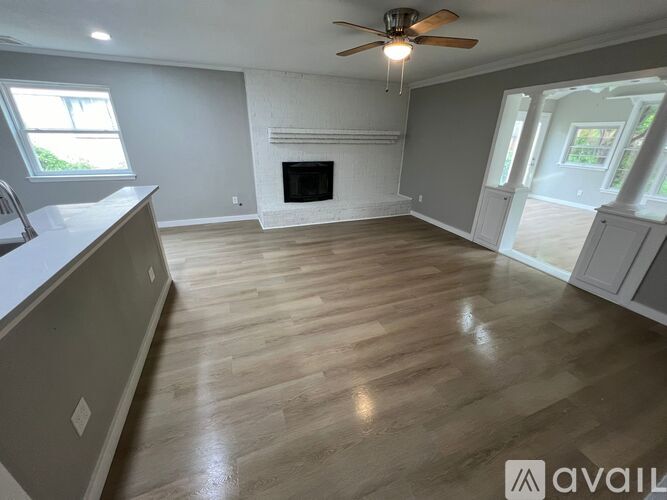 A spacious living room with a fireplace and hardwood floors.