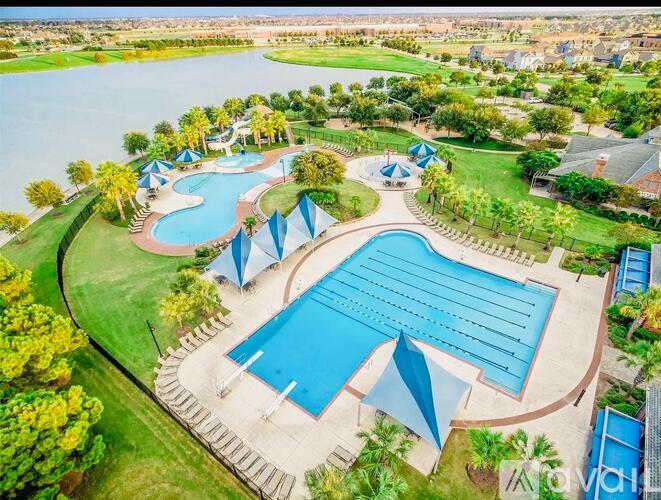 An aerial view of a resort with a large swimming pool and a smaller pool with a slide.