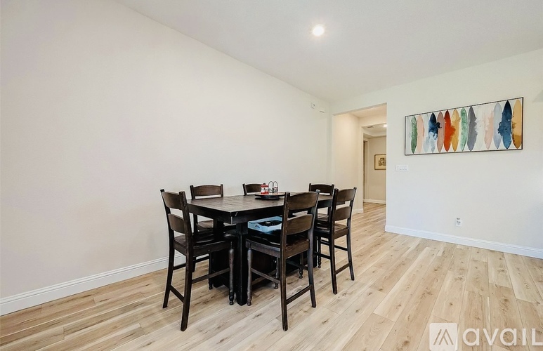 A dining room with a wooden table and chairs.
