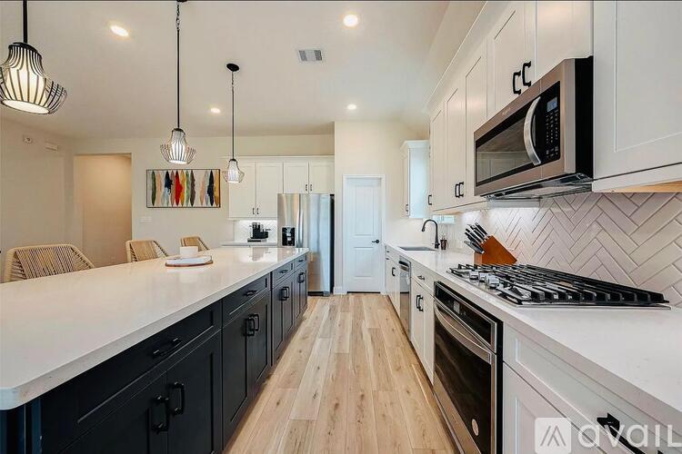 A modern kitchen with black cabinets and a white countertop.