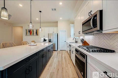 A modern kitchen with black cabinets and a white countertop.
