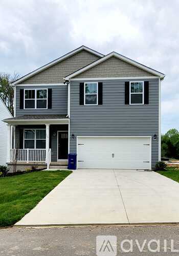 A two-story house with a garage and a driveway.