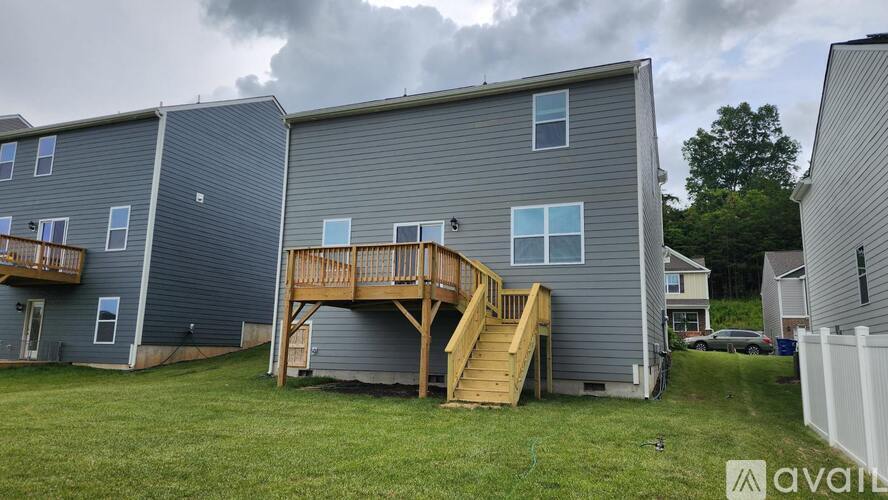 A grey house with a deck in the backyard.