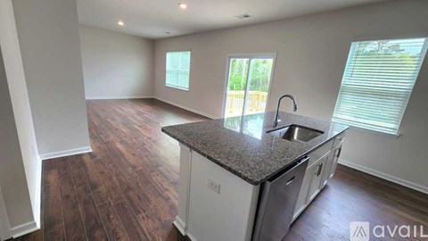 A kitchen with a granite countertop and stainless steel appliances is available for rent.