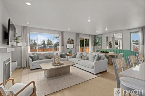 A modern living room with a white sofa set, a coffee table, and a television.