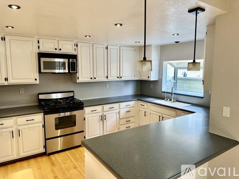 A kitchen with white cabinets and a black stove top oven.